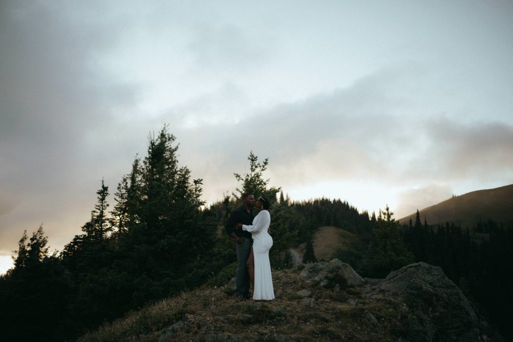 Couple enjoying the moments of being just-married while standing in Olympic National Park at sunset 